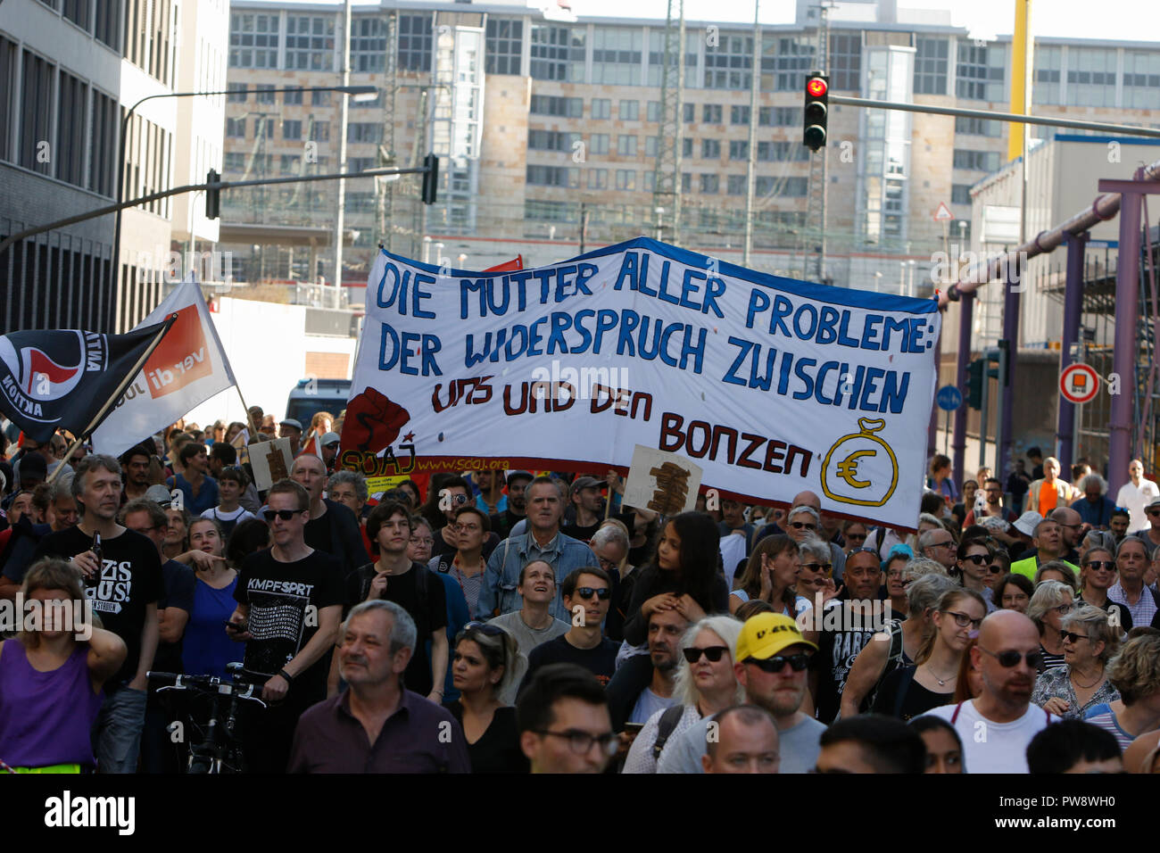 Frankfurt am Main, Deutschland. 13. Oktober 2018. Die Demonstranten halten ein Banner mit der Aufschrift "die Mutter aller Probleme: Die Meinungsverschiedenheiten zwischen uns und der fette Katzen'. Über 3.500 Menschen durch Frankfurt marschierte, um gegen Rassismus und für Toleranz zu protestieren. Sie wurden von vielen lokalen Bands, die auf dem Weg und auf den Kundgebungen begleitet. Der Protest war ein Teil von mehreren anderen Proteste gegen Rassismus in Deutschland am selben Tag. Quelle: Michael Debets/Alamy leben Nachrichten Stockfoto