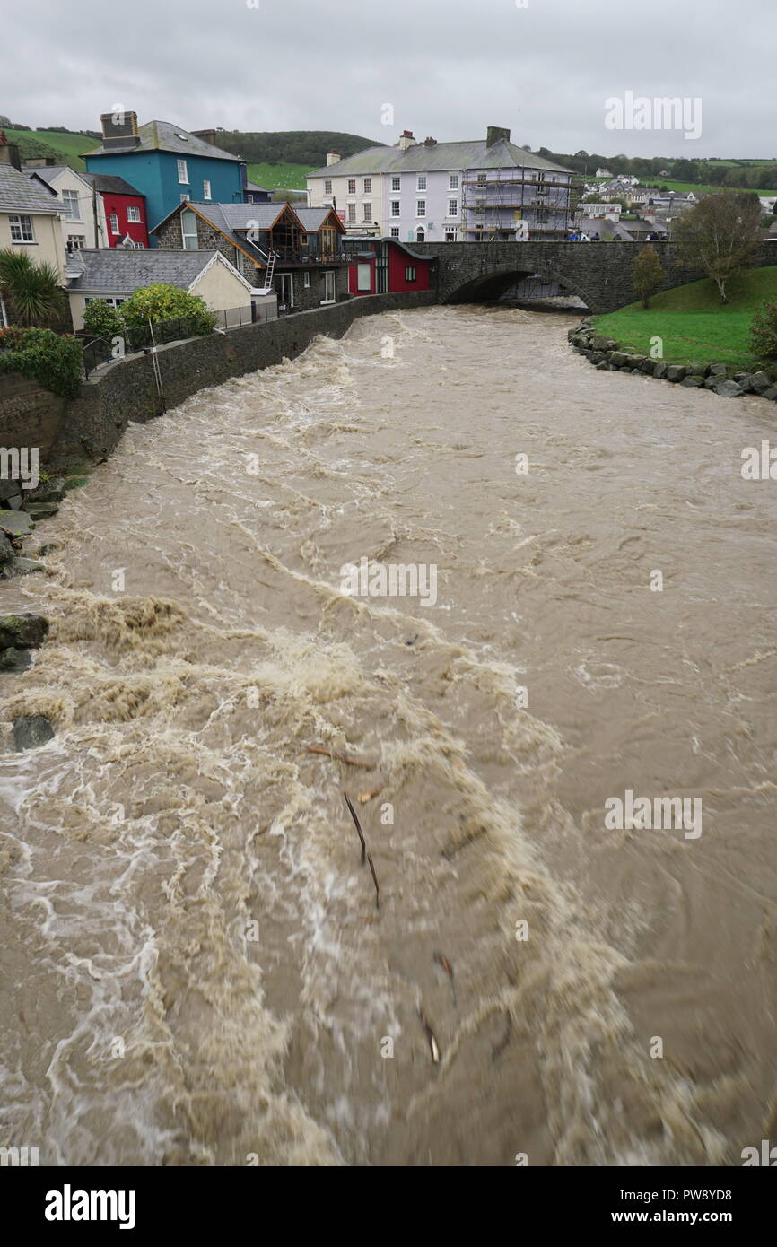 Aberaeron, UK. 13. Oktober 2018. Ein Bild der Verwüstung in Aberaeron Hafen auf der West Wales Küste am Nachmittag als schwerer Regen und starkem Wind vom Sturm Callum weiterhin Chaos zu verursachen. Flut, Wasser aus dem Fluss Aeron mit Bäumen und grossen Niederlassungen Crash in Boote es Schäden an vielen und völlig versinken. Credit: Anthony Pugh/Alamy leben Nachrichten Stockfoto