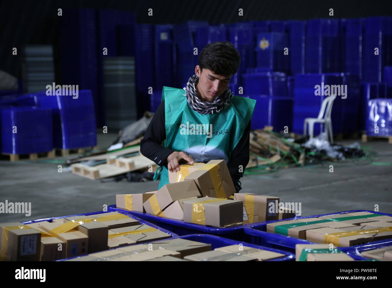 Kabul, Afghanistan. 14 Okt, 2018. Ein afghanischer Unabhängige Wahlkommission (IEC) Arbeitnehmer ordnet Kunststoff der Wahl Materialien in einem Lager in Kabul, der Hauptstadt Afghanistans, Okt. 14, 2018. Afghanische Wahlen für die Wolesi Jirga oder Unterhaus des Parlaments ist für Okt. 20 schiefergedeckt, und mehr als 2.500 Kandidaten sind Racing Art und Weise, in der 249 zu finden - Sitz Haus. Credit: Rahmat Alizadah/Xinhua/Alamy leben Nachrichten Stockfoto
