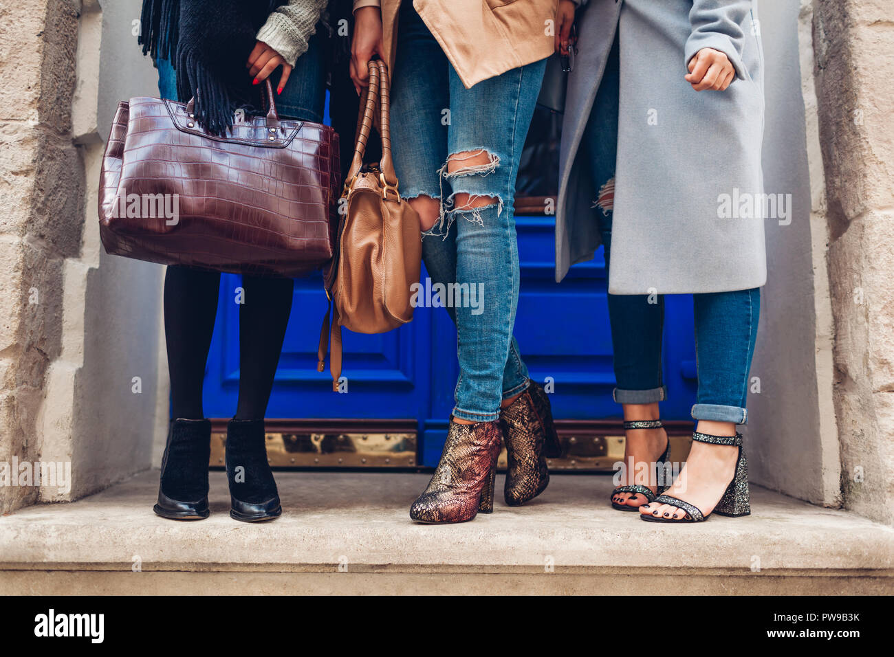 Drei Frauen, elegante Schuhe und Accessoires im Freien. Herbst Fashion  Concept. Meine Damen halten moderne weibliche Handtaschen Stockfotografie -  Alamy