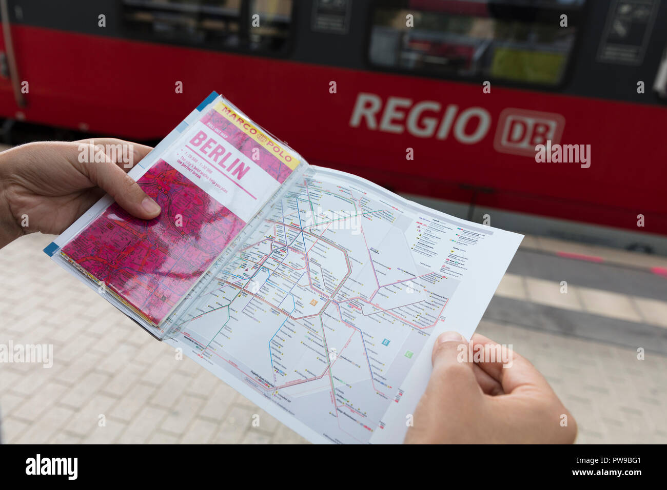 Potsdam, Berlin, Deutschland: 18. August 2018: Touristische im Marco Polo Reiseführer und Karte des Öffentlichen Verkehrs auf der Suche Stockfoto