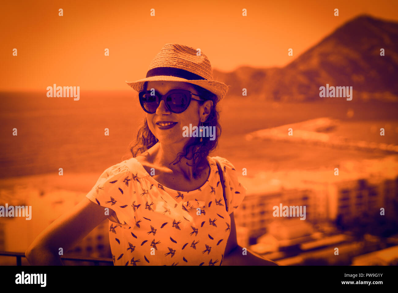 Touristische Frau mit Stroh Sonnenhut zum Mittelmeer suchen und genießen die malerische Seenlandschaft in Altea, Alicante, Spanien. Die Duplex Wirkung - Oran Stockfoto