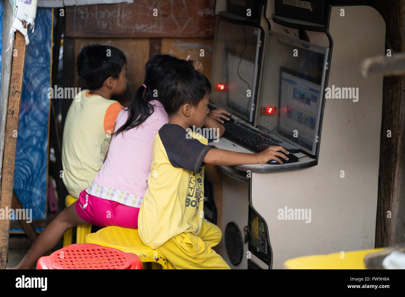 Image der jungen philippinischen Kindern den Zugang zum Internet über kleine Stände in einem slumgebiet, Cebu City, Philippinen. Stockfoto