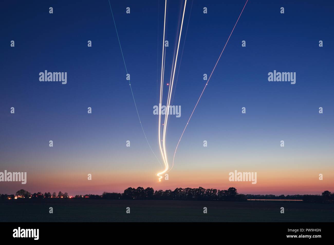 Leichte Spuren von Flugzeug bei der Landung am Flughafen nach Sonnenuntergang. Prag, Tschechische Republik. Stockfoto