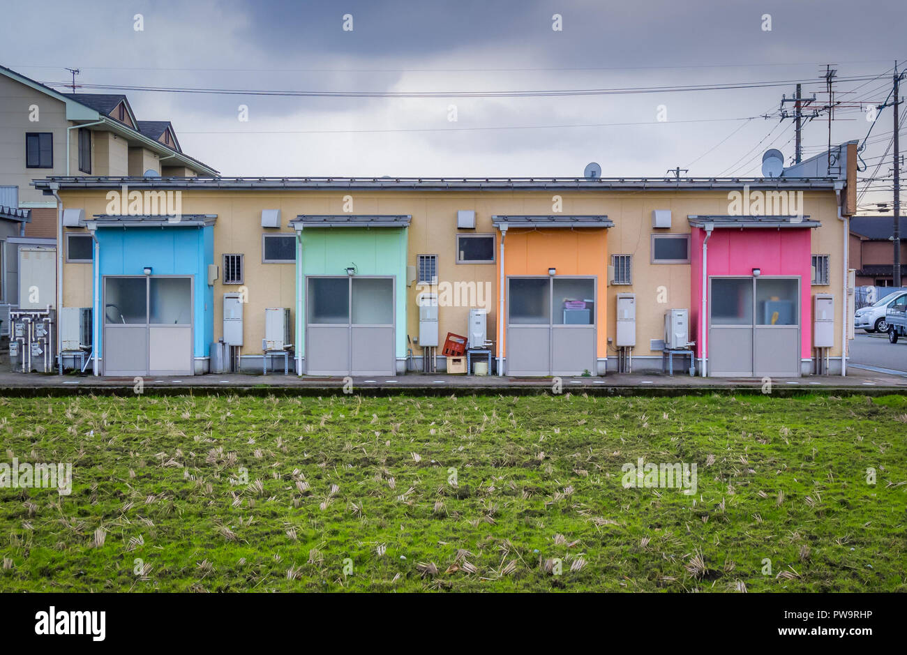 Gebäude mit 4 bunten Türen, mit kultiviertem Land im Vordergrund. Kanazawa, Japan, Winter. Stockfoto