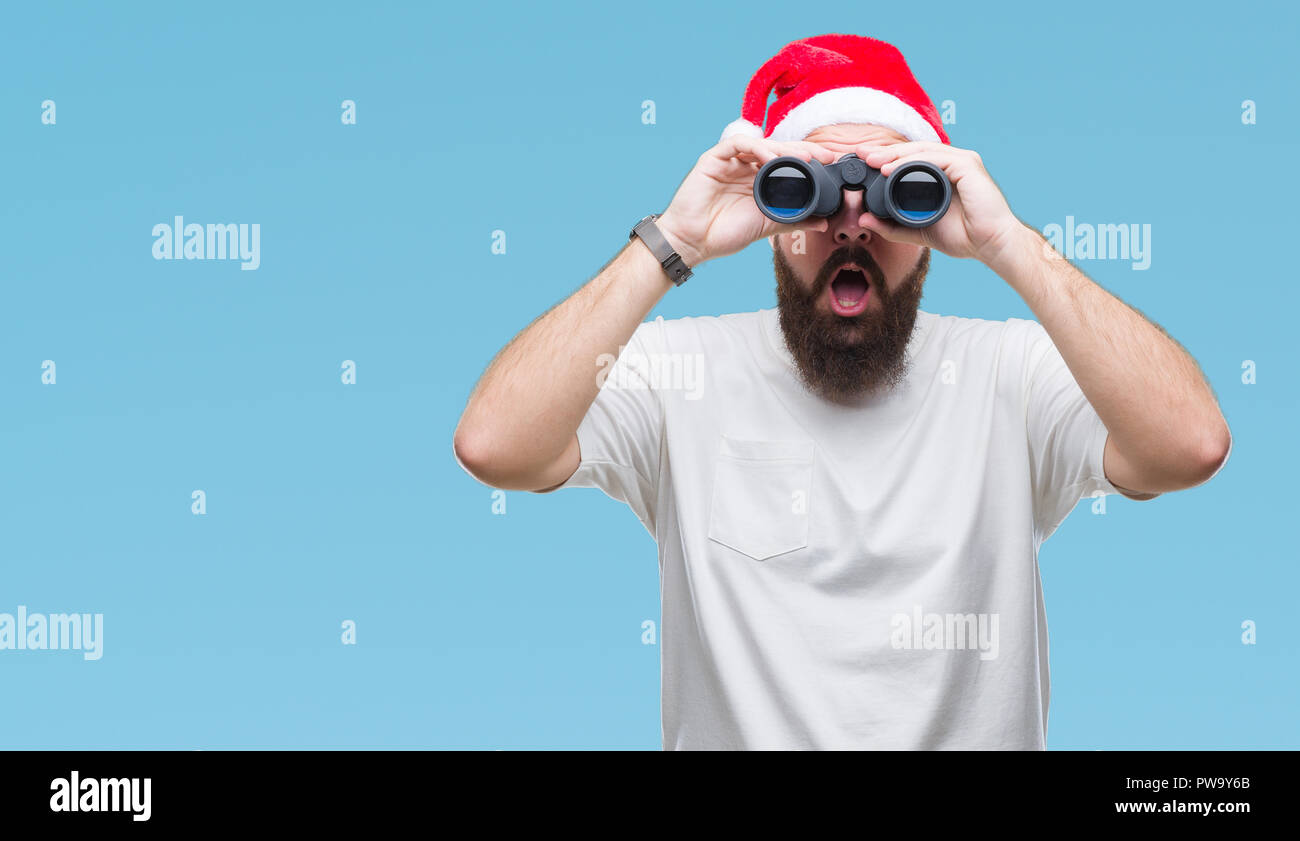 Junge kaukasier hipster Mann mit Mütze, obwohl Fernglas über isolierte Hintergrund im Schock Angst mit einer Überraschung Gesicht, Angst und Stockfoto