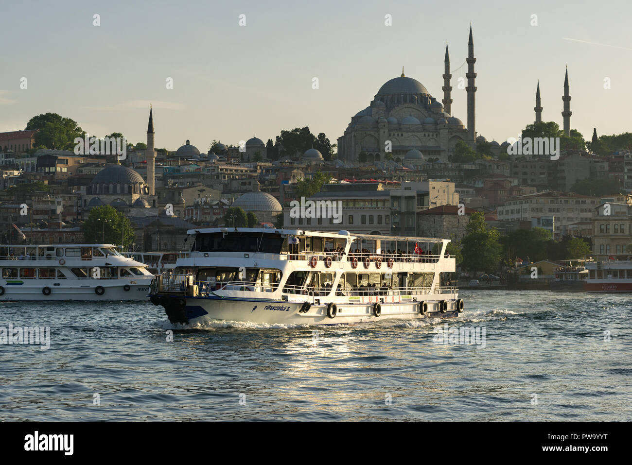 Eine Fähre mit Passagieren auf Segel auf dem Bosporus mit Suleymaniye Moschee im Hintergrund, Istanbul, Türkei Stockfoto