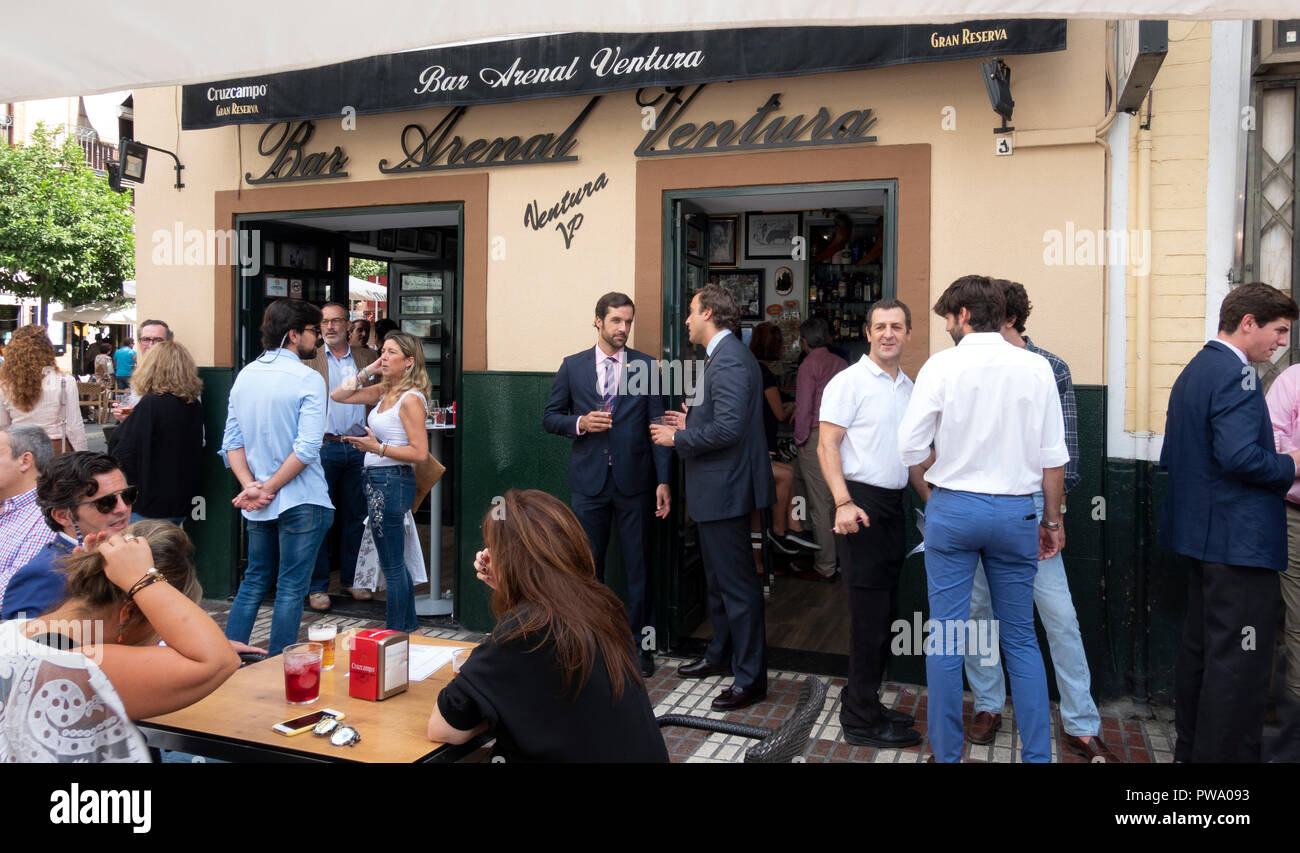 Zwei junge spanische Geschäftsleute in Anzügen und Krawatten Sharing bei einem Drink und einem Gespräch außerhalb des Arenal Ventura Bar in Sevilla, Andalusien, Spanien Stockfoto