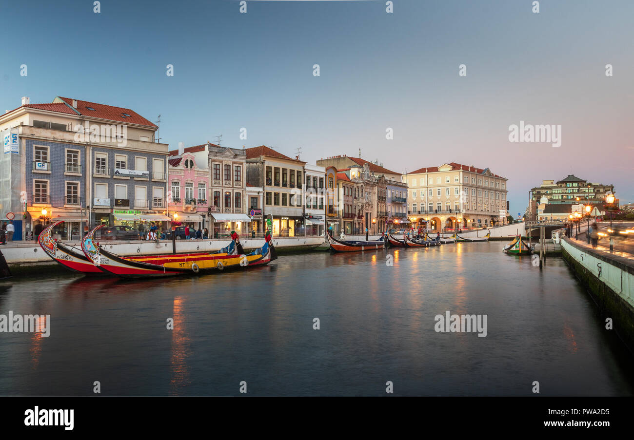 Aveiro, Portugal. Juli 28, 2018. Den zentralen Kanal in Aveiro, mit mehreren Moliceiros verankert und Häuser im Jugendstil im Hintergrund in der Abenddämmerung. Zentrum von Stockfoto