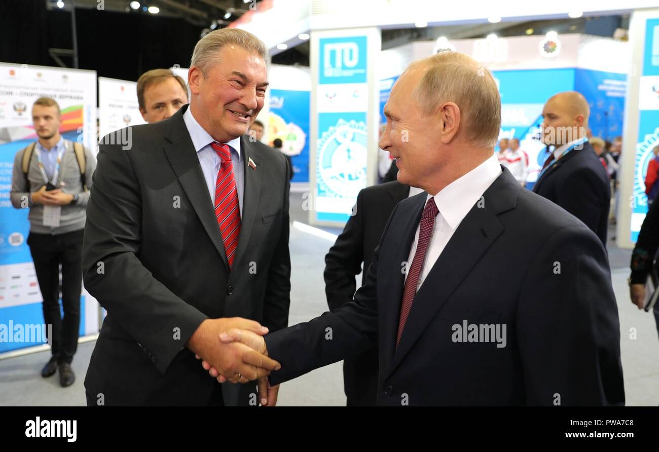 Der russische Präsident Wladimir Putin rüttelt Hände mit Vladislav Tretyak, pensionierter legendäre russische Eishockey Torwart bei einem Rundgang durch die Ausstellung Moderne Sport: Innovationen und Perspektiven Oktober 10, 2018 in Perm, Russland. Stockfoto