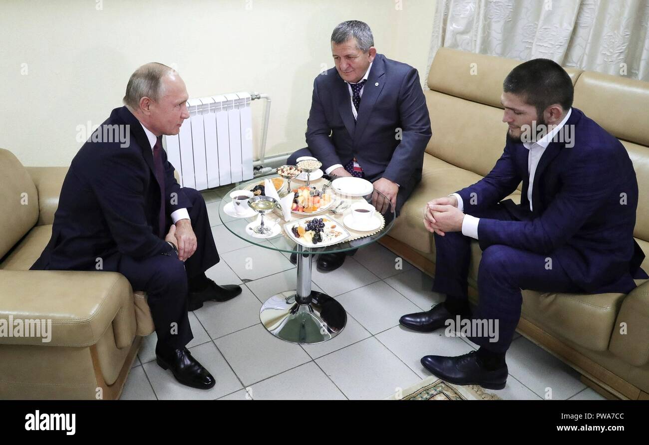 Der russische Präsident Wladimir Putin, Links, beglückwünscht Khabib Nurmagomedov, rechts, zum Gewinn der UFC-Meisterschaft als Vater und Trainer Abdulmanap Nurmagomedov am 10. Oktober in Perm, Russland 2018 aussieht. Stockfoto
