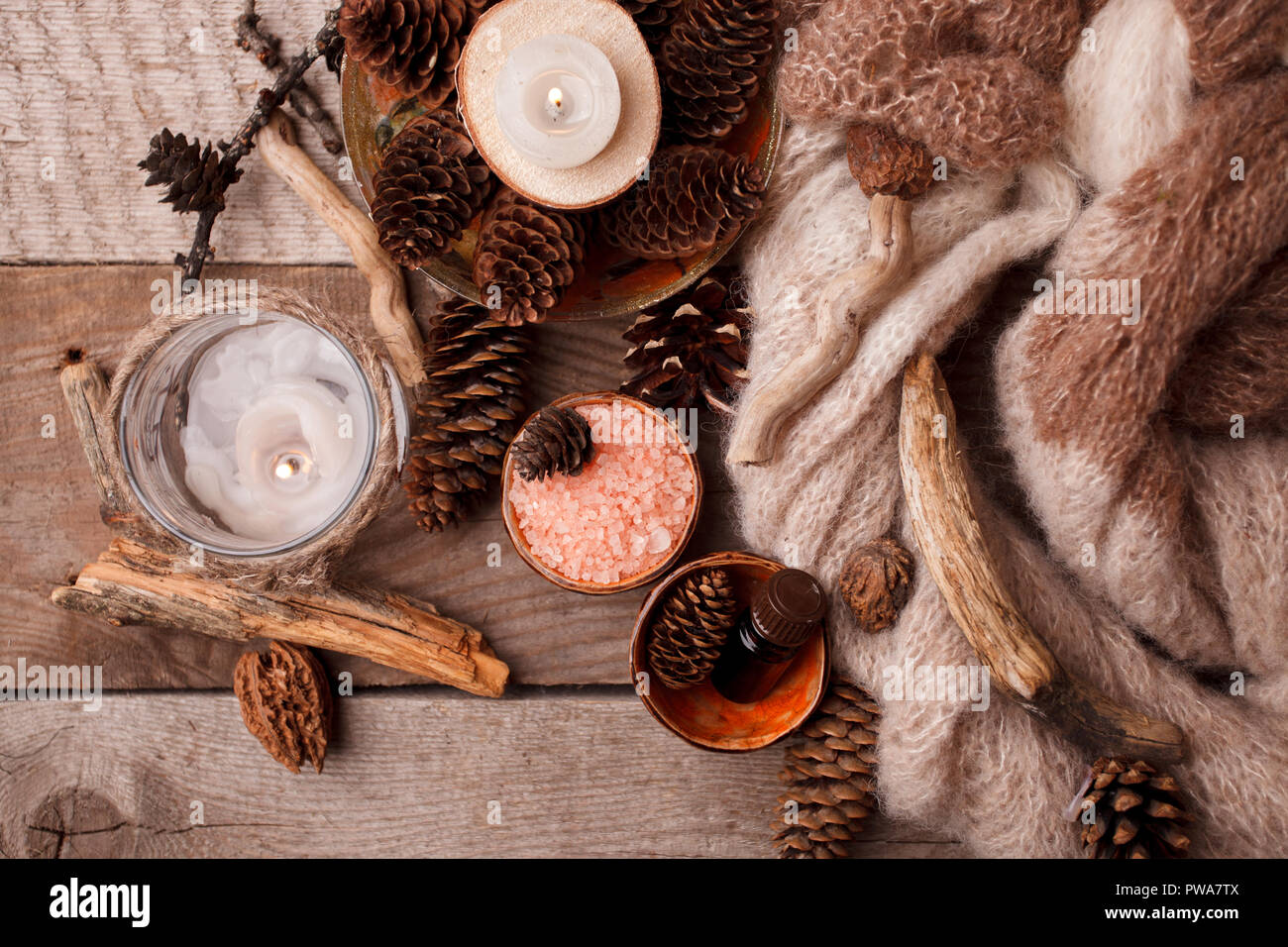 Spa und Wellness Umgebung mit Meer Salz, Öl Essenz, Kegel und Kerze, Holzdekor auf Holz- Hintergrund. Herbst Herbst Winter Wellness Konzept, entspannen Sie sich, ein Stockfoto