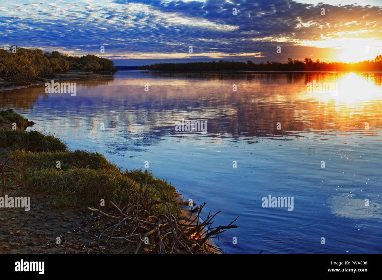 Reflexion der Morgendämmerung und Sonne der Herbst Himmel in der aktuellen Flusswasser. Verdunstung aus der Oberfläche, gemächlichen Fluss, ein Gefühl der Stille Stockfoto