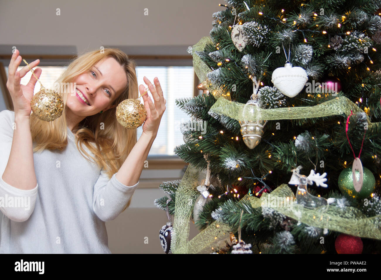 Junge Frau schmücken Weihnachtsbaum Stockfoto