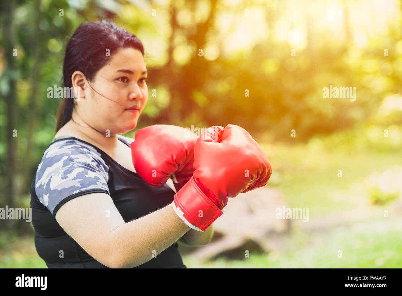 Kampf gegen Fett Konzept. Mädchen Fettsäuren Frau boxing Kämpfer mit Gewicht zu verlieren Stockfoto