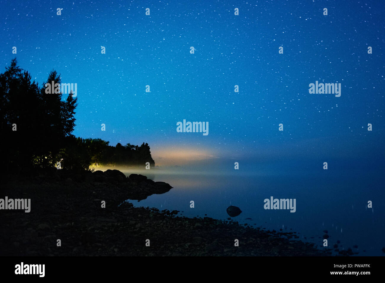 Die sternenklaren Nacht am See. Nebel über Wasser im Horizont. Stockfoto