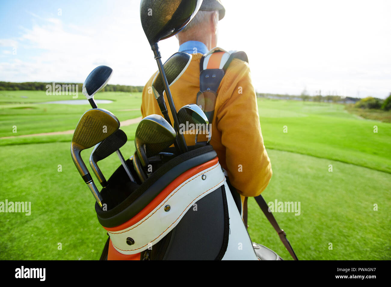 Bündel Golfschläger in der Tasche über der Schulter der professionellen Spieler verschieben Entlang großer grüner Bereich Stockfoto