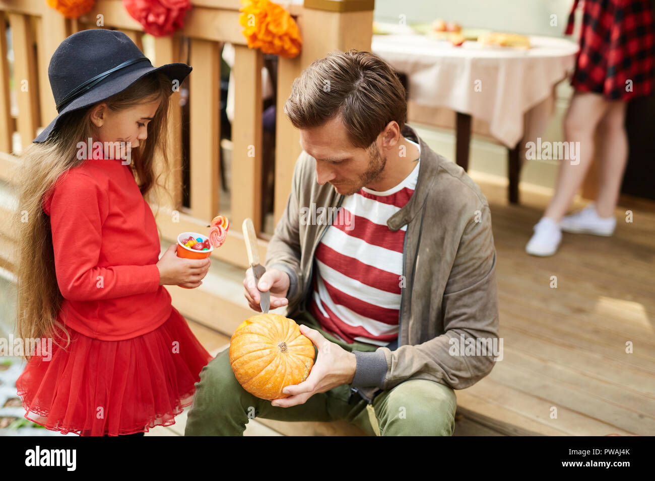 Süße kleine Mädchen suchen Bei Dad, Jack-o-Lantern für Ihre auf Halloween Tag Stockfoto