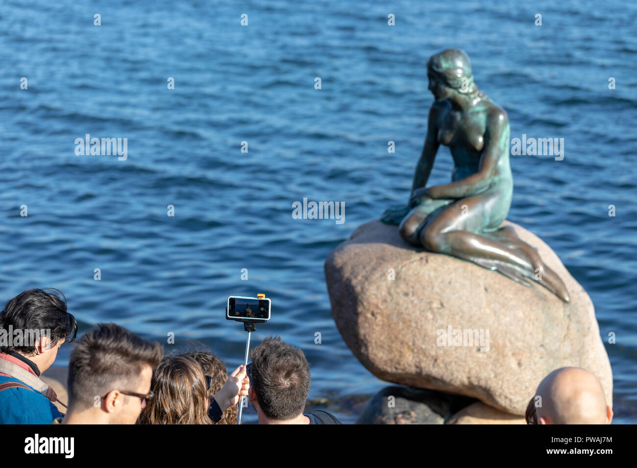 Eine Gruppe von Touristen mit einem selfie Stick von der Kleinen Meerjungfrau, Kopenhagen, Dänemark Stockfoto