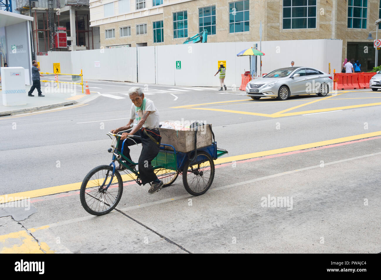 Singapur - 18. FEBRUAR 2017: Mann, ein Dreirad auf der Straße in Singapur. Singapur ist der wichtigste Finanzplatz in Asien Stockfoto