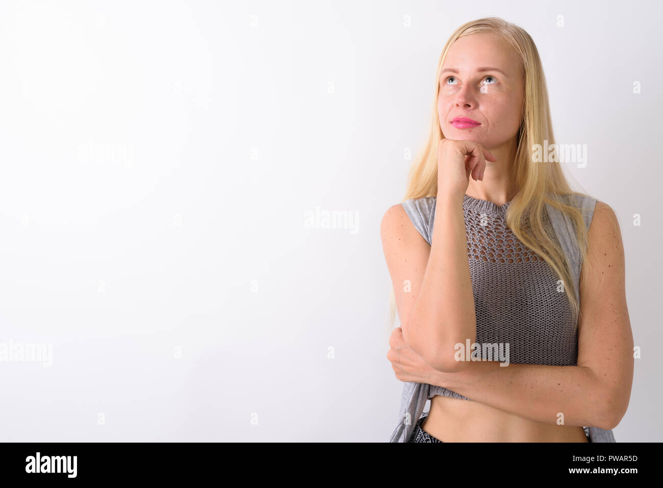 Schöne blonde Frau, die gegen die weißen Hintergrund Stockfoto