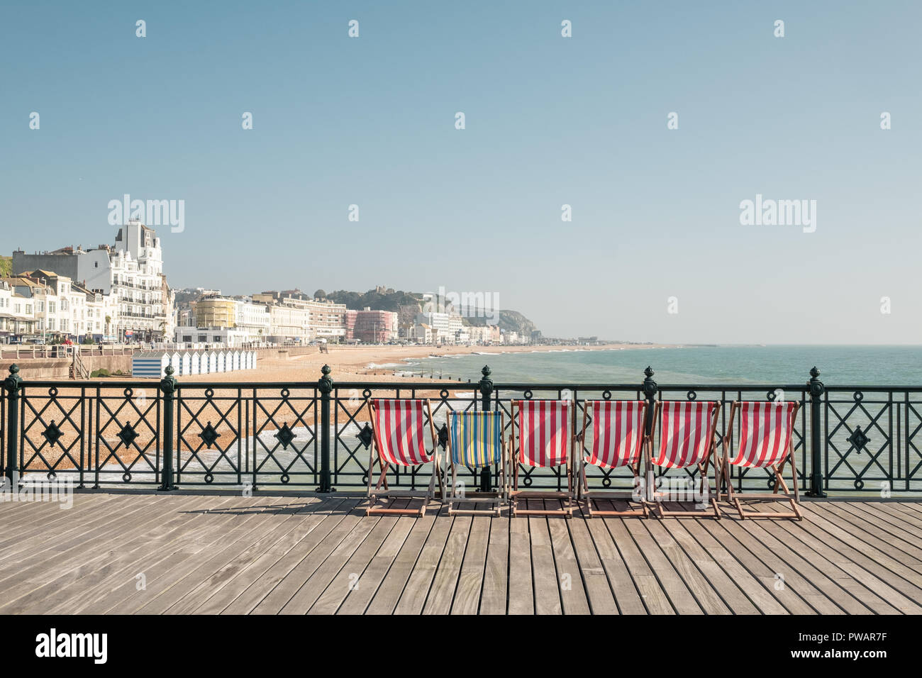 Liegestühle am Pier von Hastings, East Sussex, Großbritannien Stockfoto