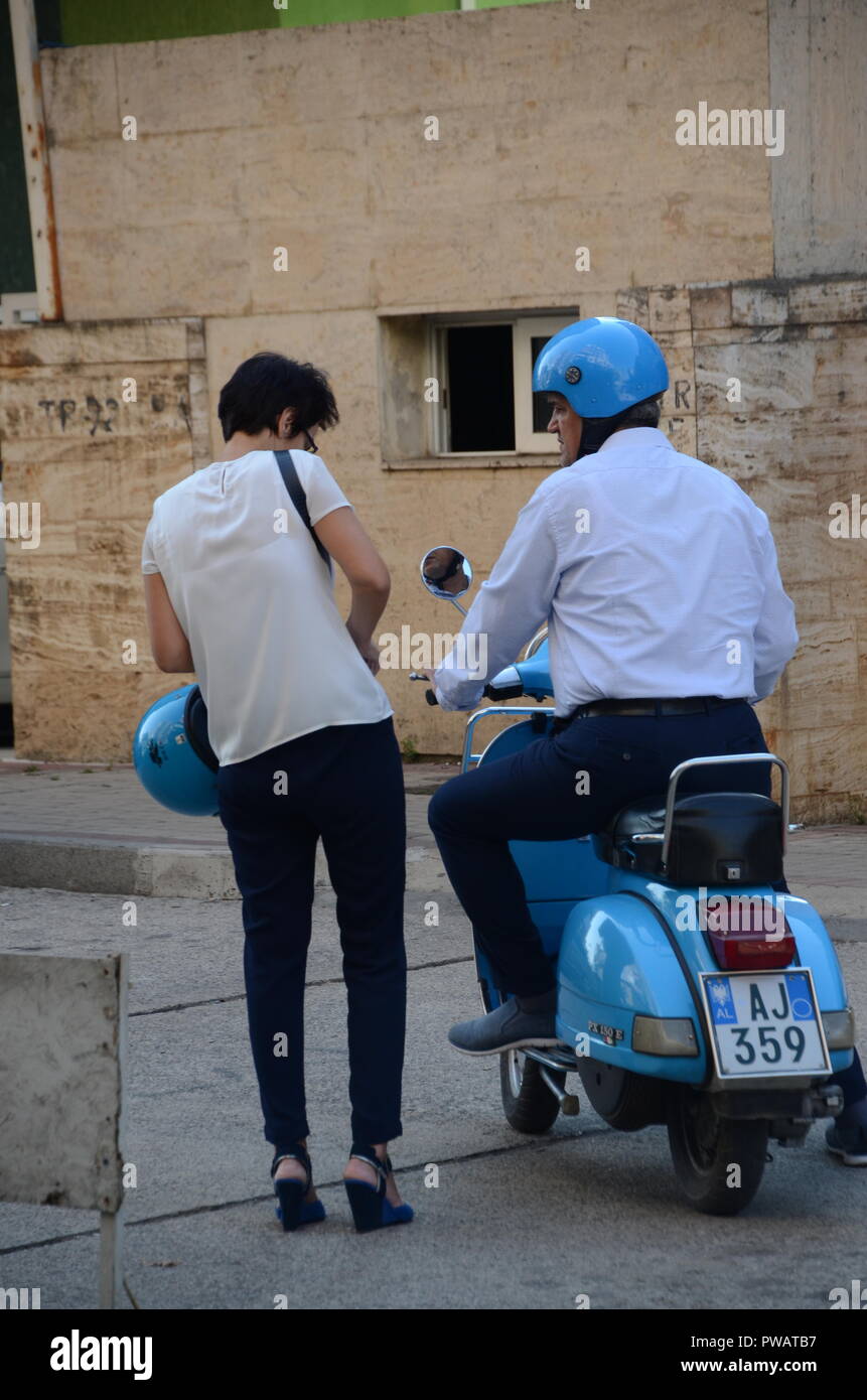Ein Paar auf einem blauen Vespa mit übereinstimmenden blauen Schutzhelme Tirana Albanien Stockfoto