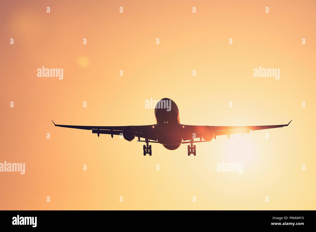 Low Angle View Flugzeug Landung gegen Golden Sky bei Sonnenuntergang. Stockfoto