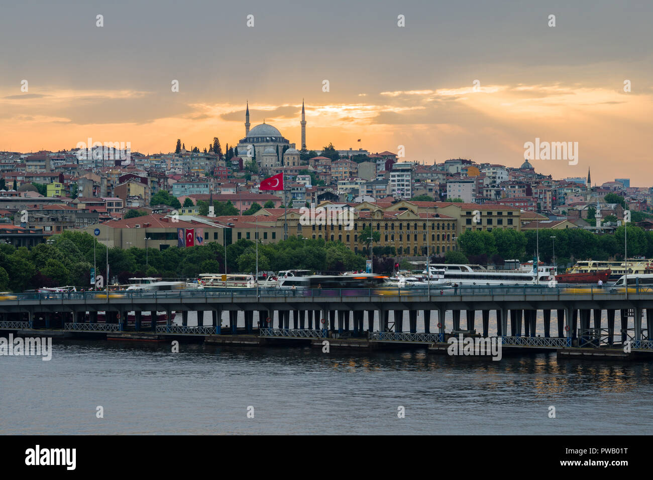 Anzeigen von Unkapanı Brücke mit Verkehr und das Goldene Horn mit Moschee im Hintergrund bei Sonnenuntergang, Istanbul, Türkei Stockfoto