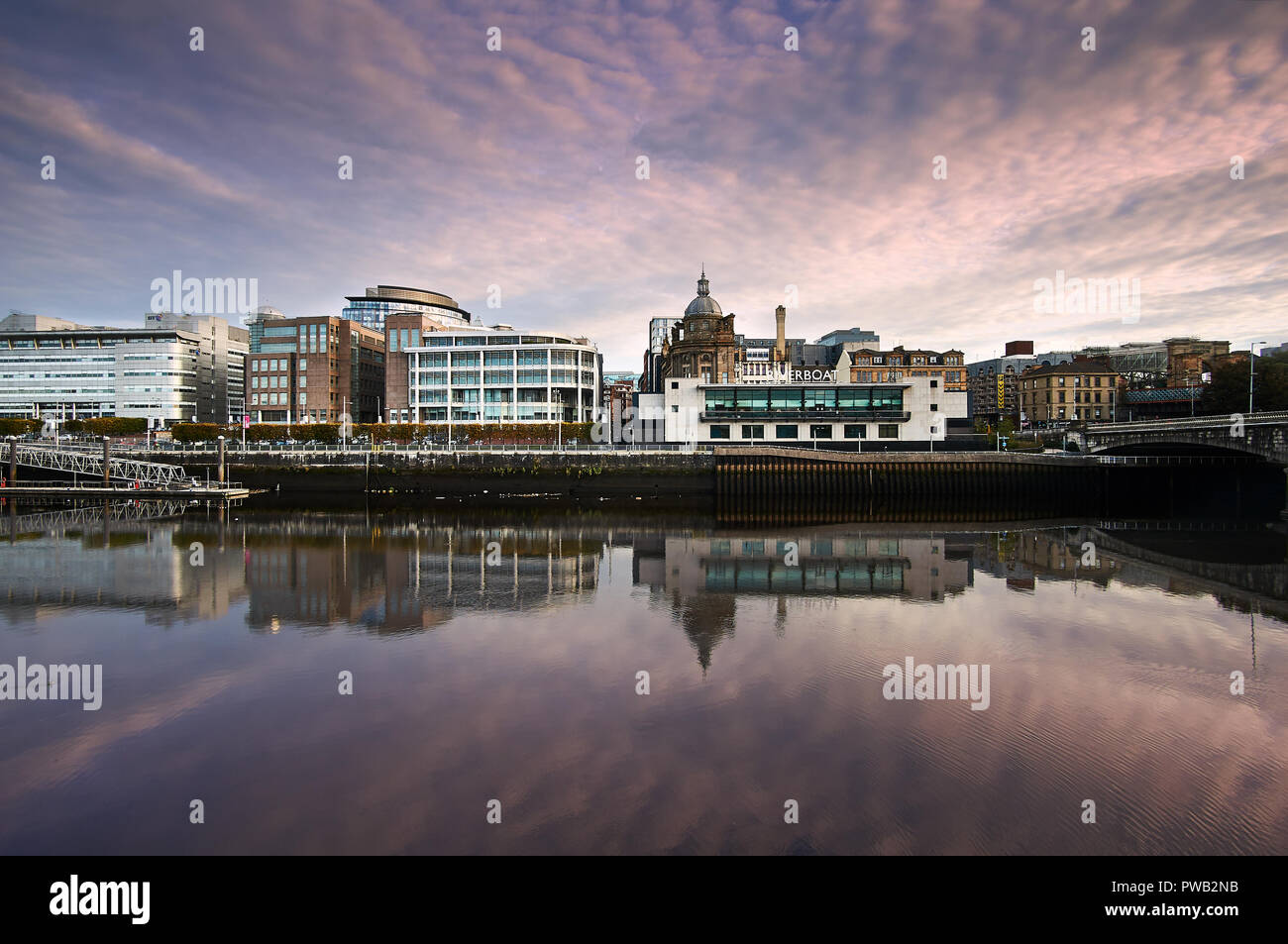 Rosa und Lila Himmel bei Sonnenaufgang über den Fluss Clyde mit dem Riverboat casino in Sicht. Stockfoto
