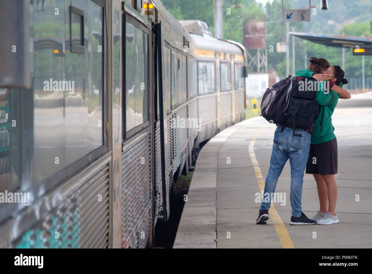 Zwei Menschen umarmt, während Abschied von einander, bevor Sie sich auf einen Zug auf einem Bahnhof Plattform Stockfoto