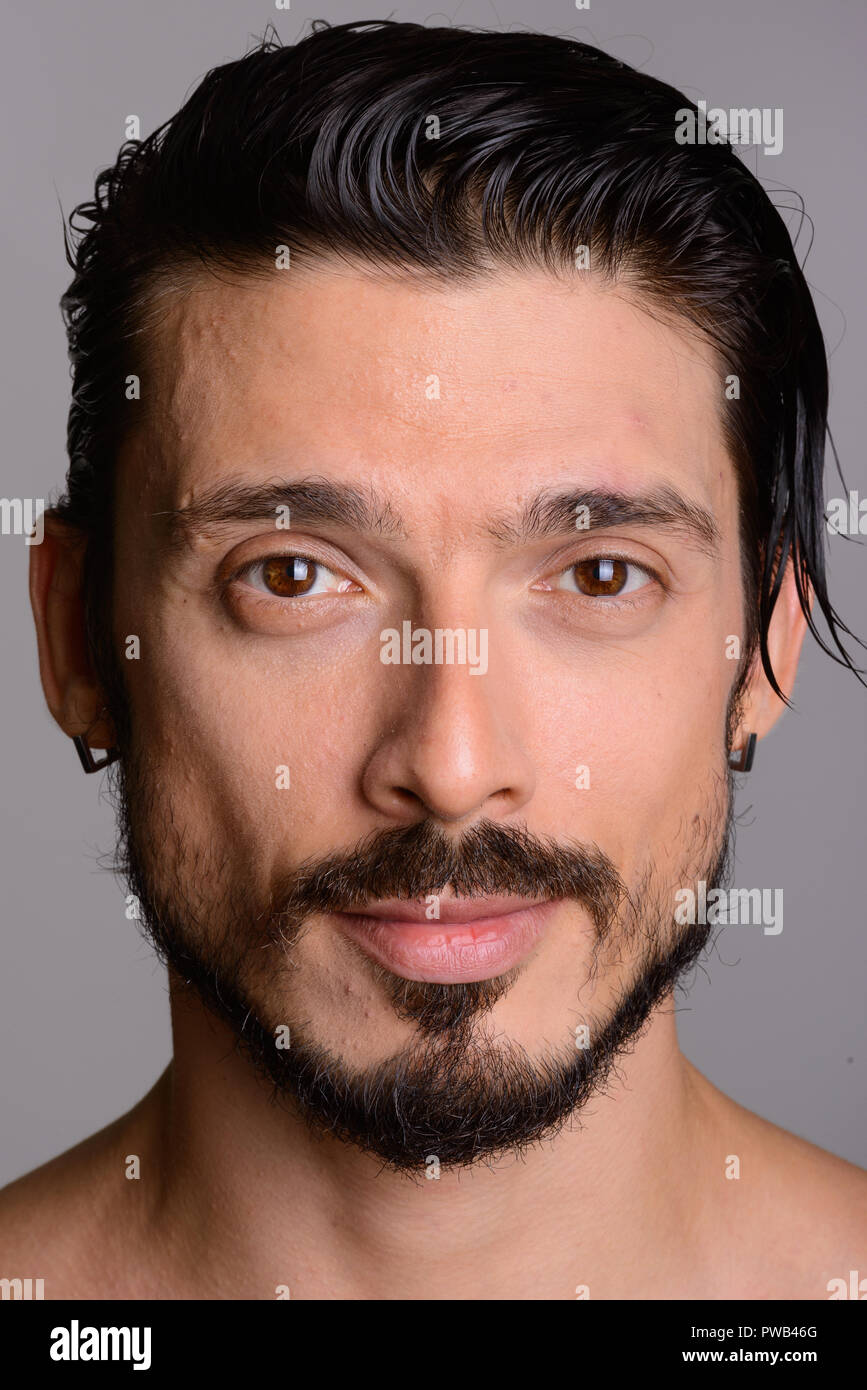 Angesichts der stattlichen Mann gegen grauer Hintergrund Stockfoto