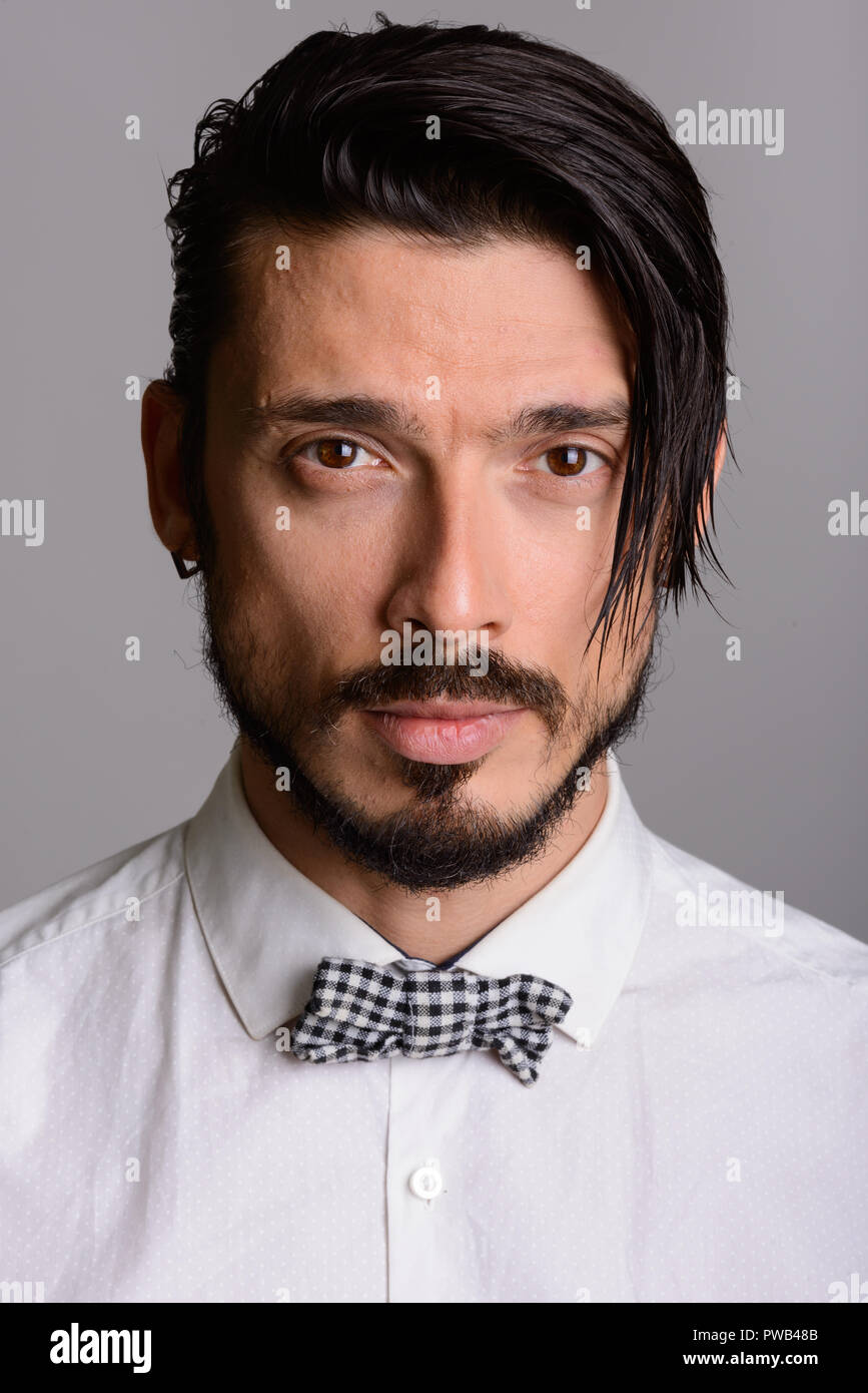 Angesichts der stattlichen Mann gegen grauer Hintergrund Stockfoto