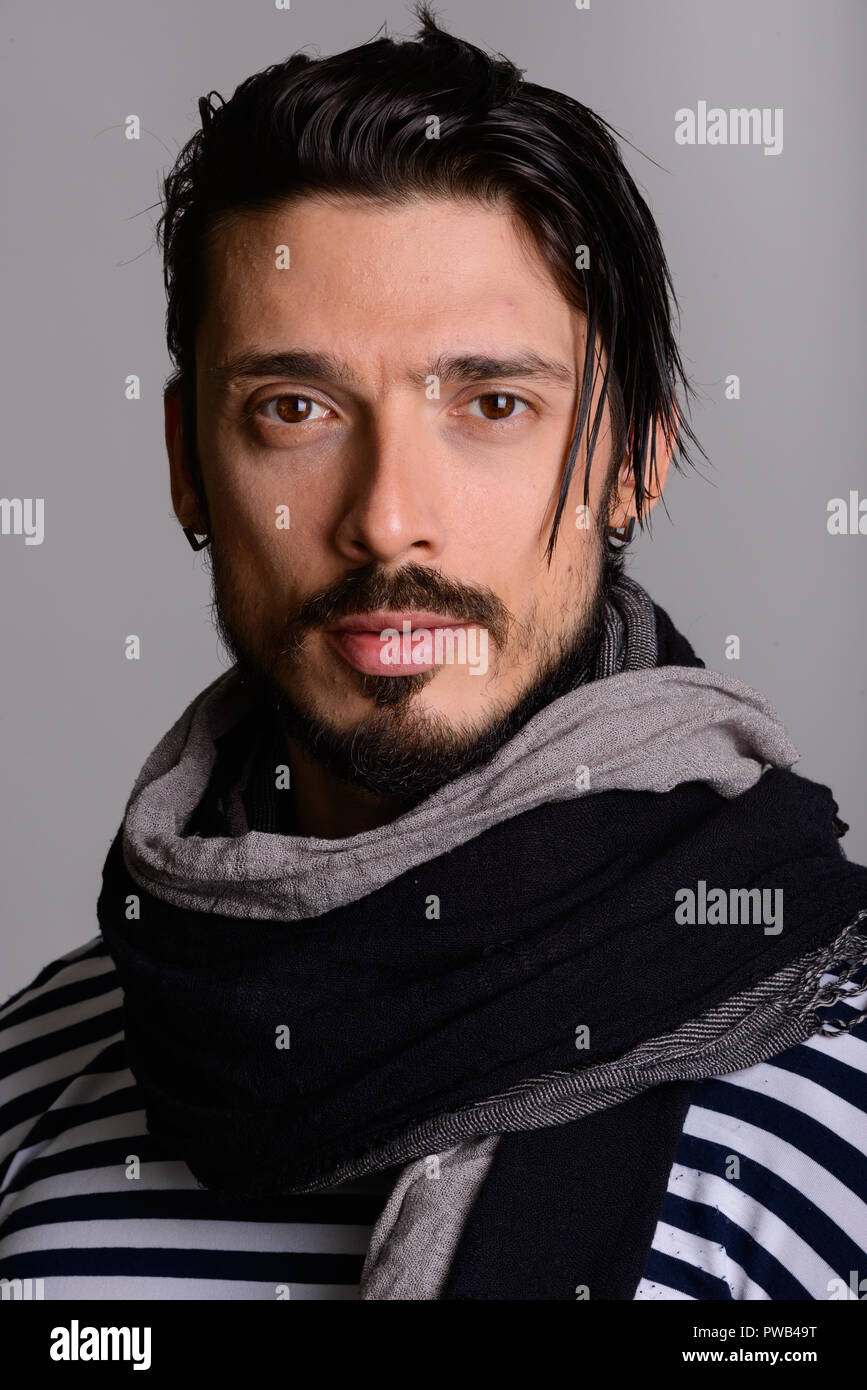 Angesichts der stattlichen Mann mit Schal gegen grauer Hintergrund Stockfoto
