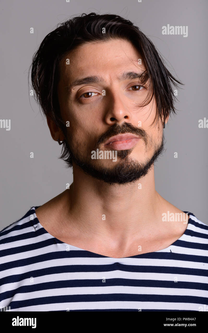 Angesichts der stattlichen Mann gegen grauer Hintergrund Stockfoto