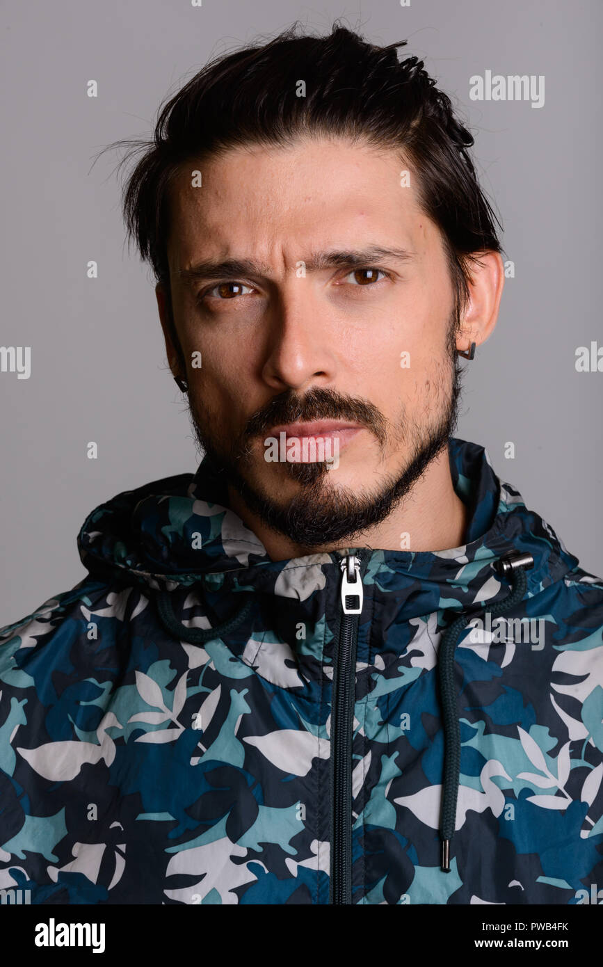 Angesichts der stattlichen Mann gegen grauer Hintergrund Stockfoto