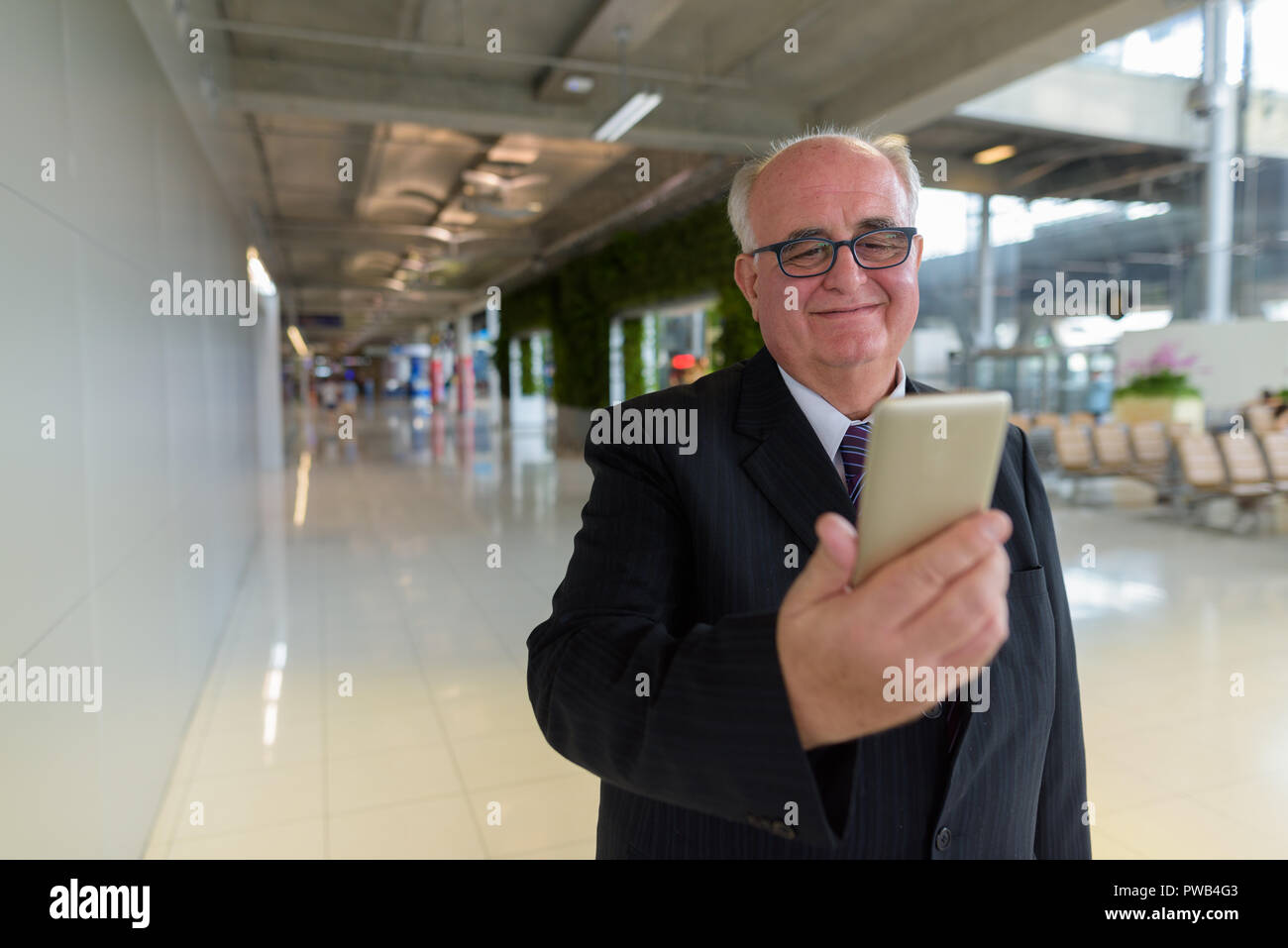 Übergewicht älterer Geschäftsmann Lounging rund um den Flughafen von Ban Stockfoto