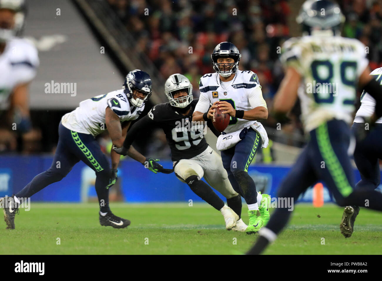 Wembley Stadion, London, UK. 14 Okt, 2018. NFL in London, Spiel eins, Seattle Seahawks gegen Oakland Raiders; Russell Wilson von den Seattle Seahawks sieht auf den Pass zu Doug Baldwin Credit: Aktion plus Sport/Alamy Leben Nachrichten zu werfen Stockfoto