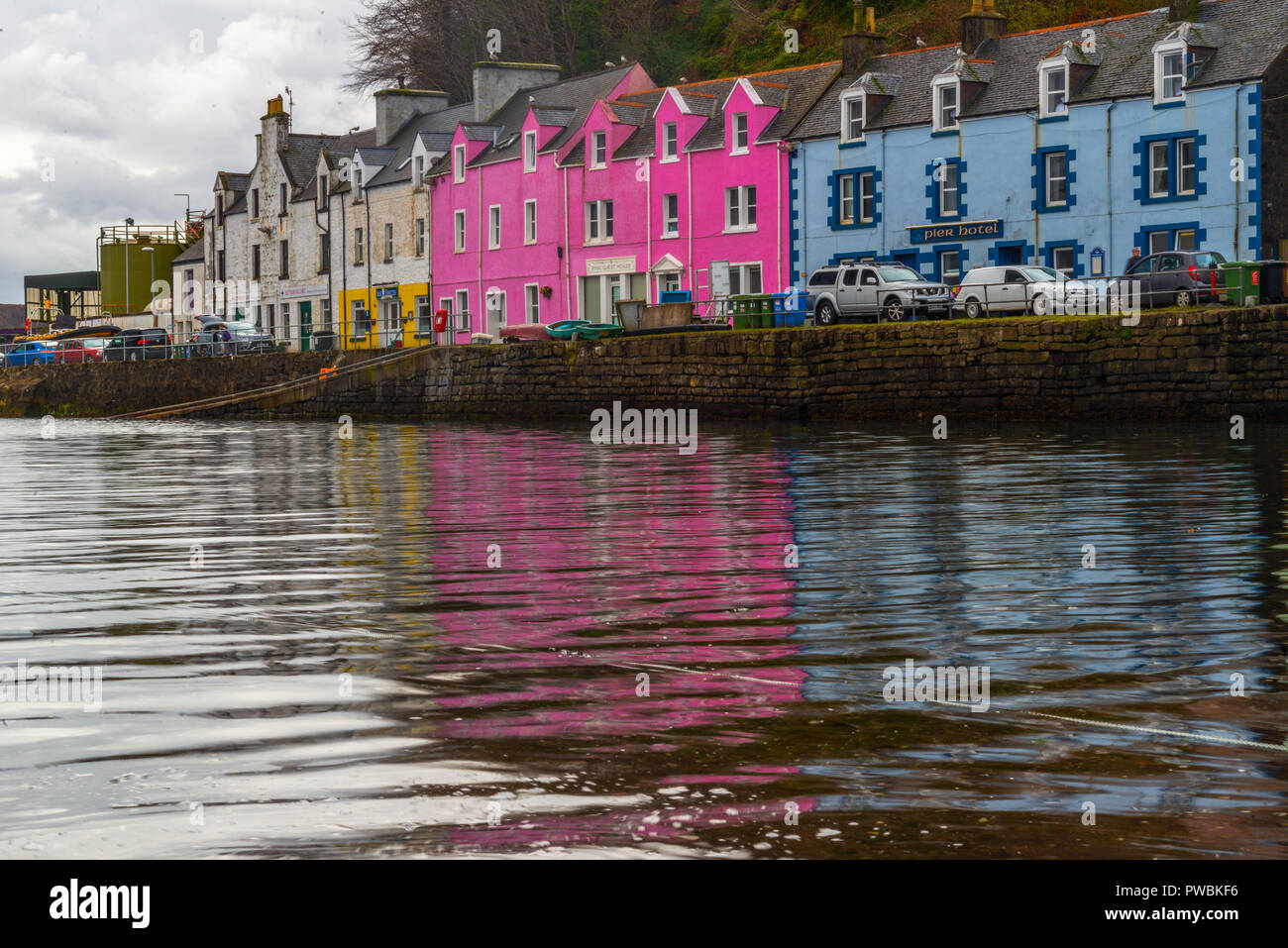 Bunte Häuser am alten Hafen von Portree spiegeln sich im Wasser. Isle of Skye, Schottland, Vereinigtes Königreich Stockfoto