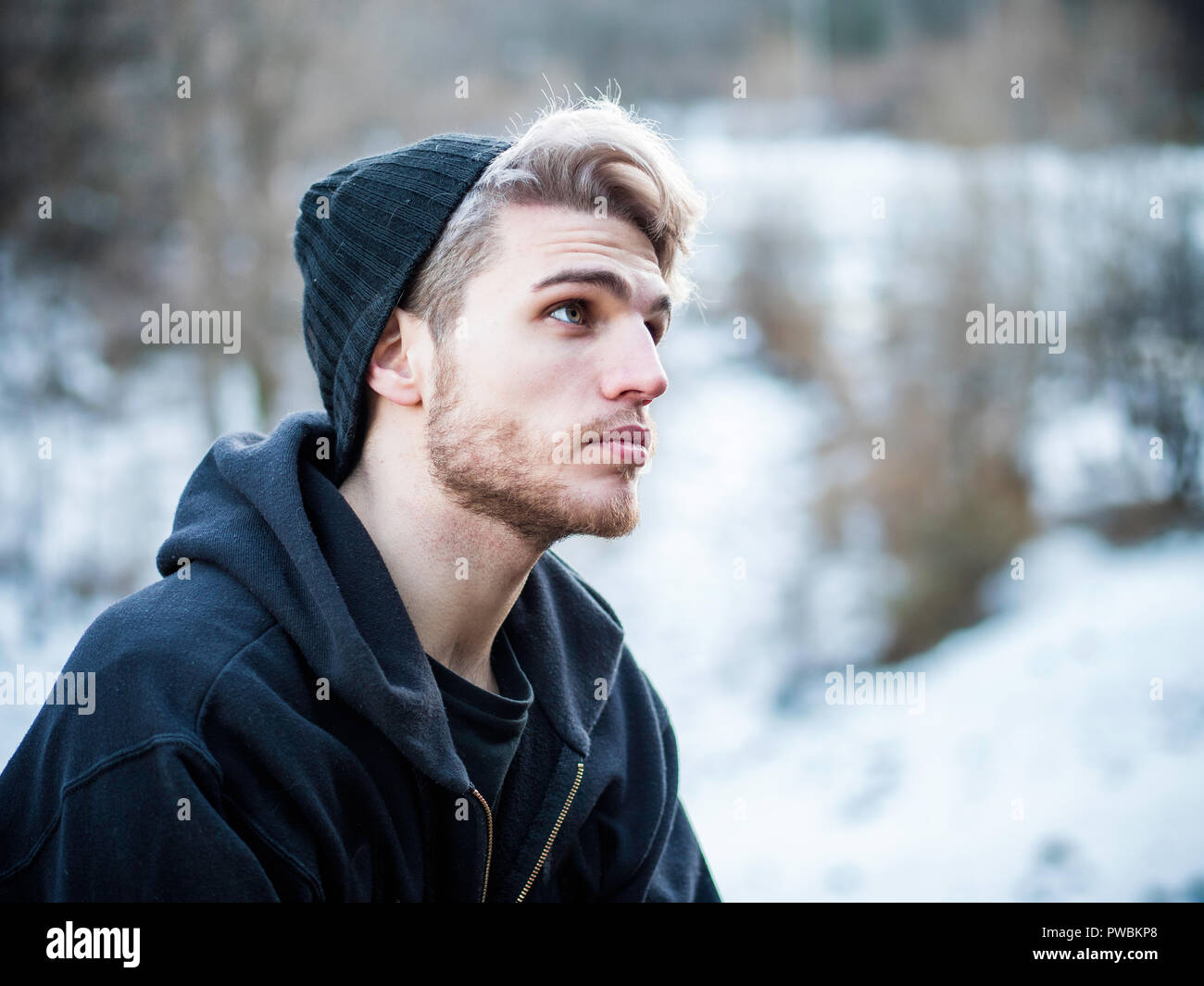 Schöner Mann im Schnee für die Kamera posieren Stockfoto
