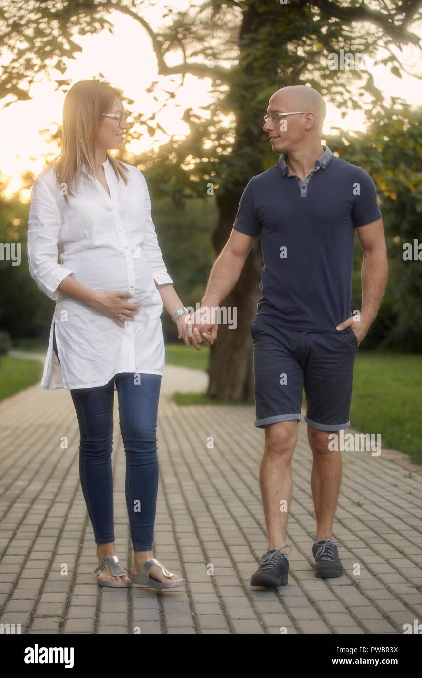 Junges Paar, reden miteinander, halten sich an den Händen. Walking im Park Trail. Stockfoto