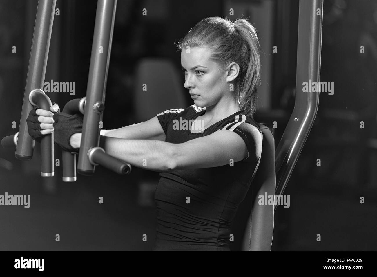 Frau an der Sporthalle Arme Übungen auf einer Maschine Stockfoto