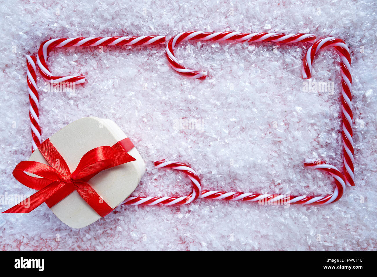 Weihnachten Geschenk und Candy Cane Rahmen auf Schnee Hintergrund Stockfoto