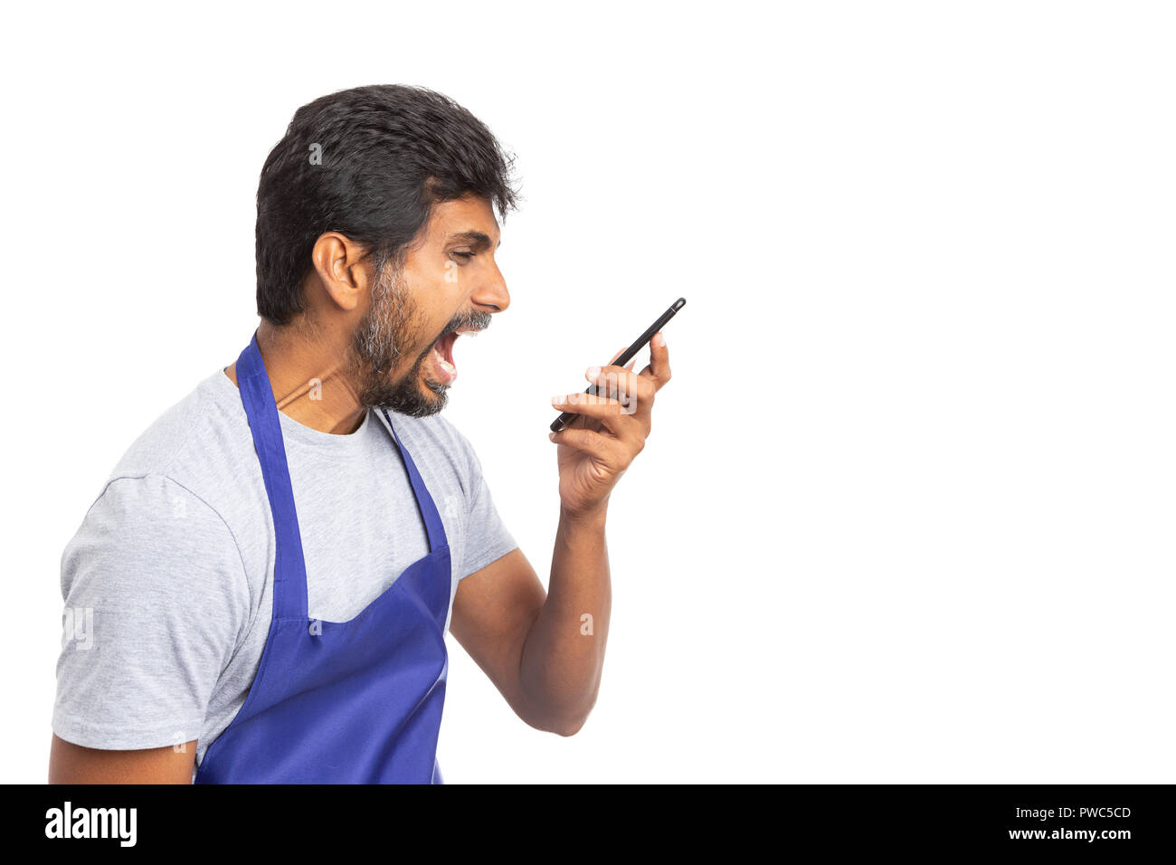 Verärgert indische SB-Warenhaus oder Supermarkt männliche Mitarbeiter am Telefon mit offenen Mund auf weißem studio Hintergrund kreischen Stockfoto