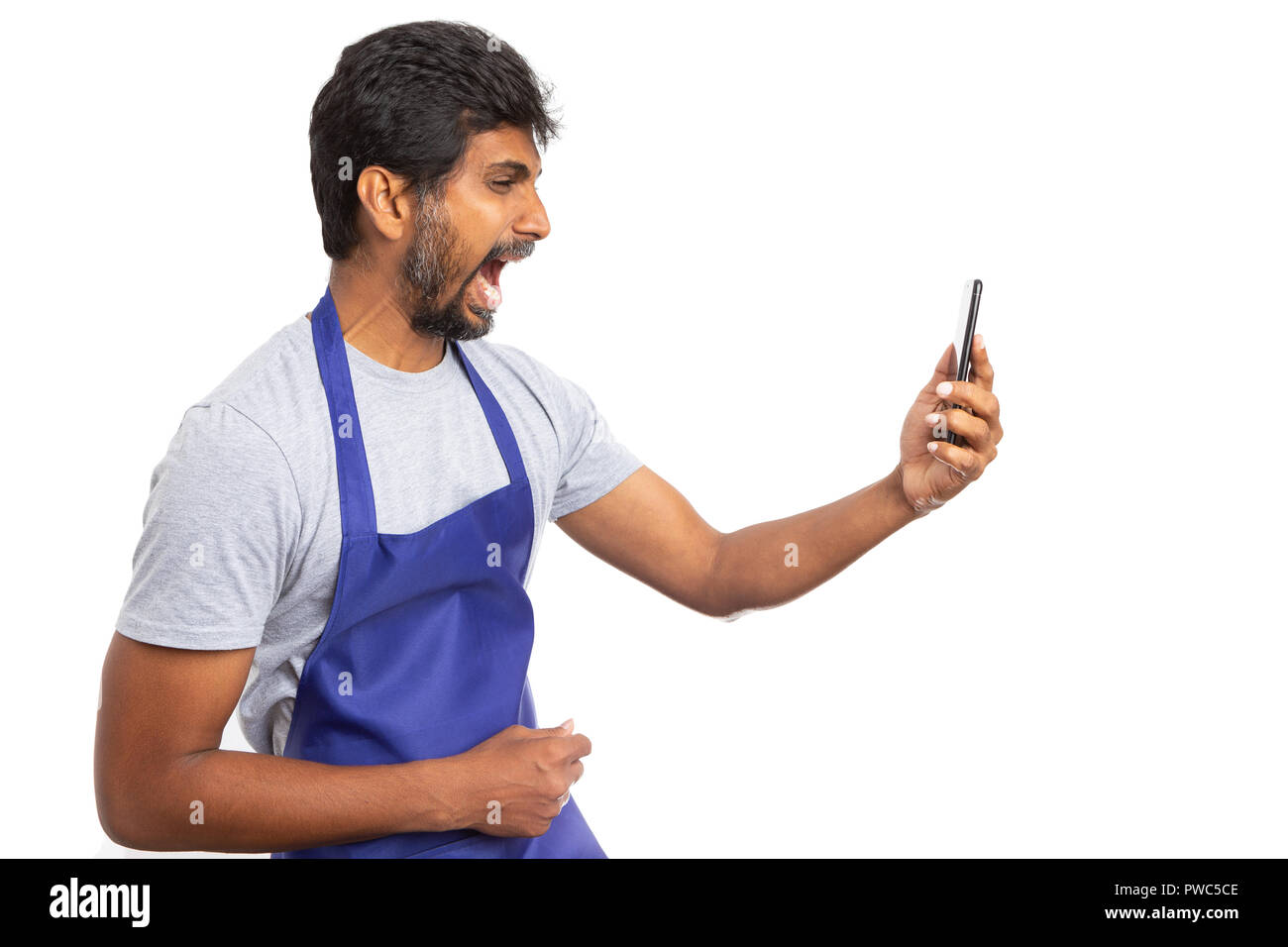Mad Supermarkt oder SB-Warenhaus indischer Mitarbeiter am Telefon in Video kreischen Chat als frustriert Konzept auf weißem Hintergrund Stockfoto
