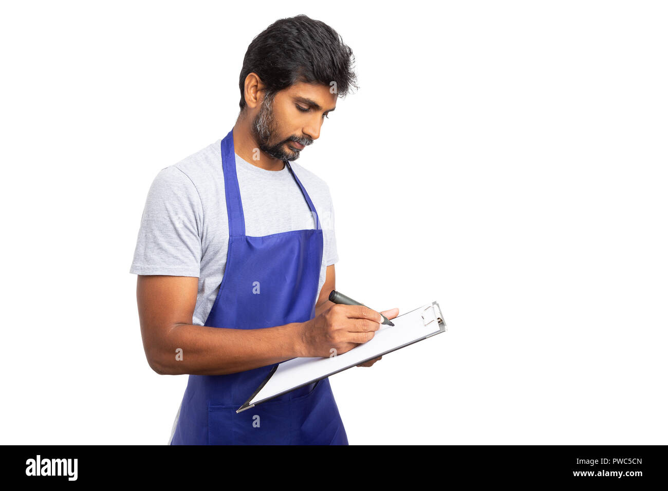 Store Manager oder indischen Eigentümer schriftlich auf Papier Checkliste Zwischenablage mit fokussierten Blick auf weiße studio Hintergrund isoliert Stockfoto