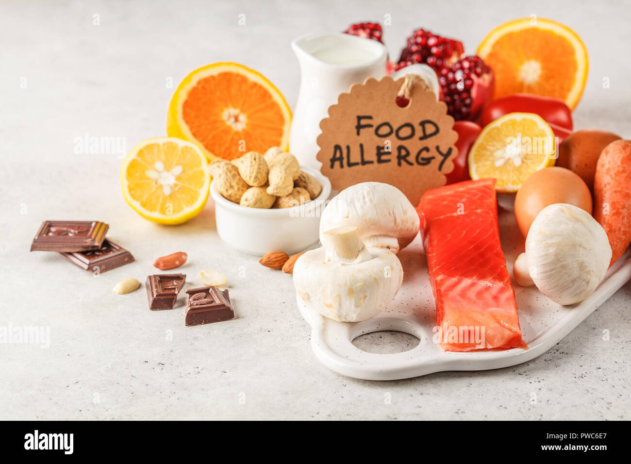 Allergie essen Konzept. Allergien, Fisch, Eier, Zitrusfrüchte, Schokolade, Pilze und Nüsse. Gesundheit und Medizin in Essen. Weißer Hintergrund. Stockfoto