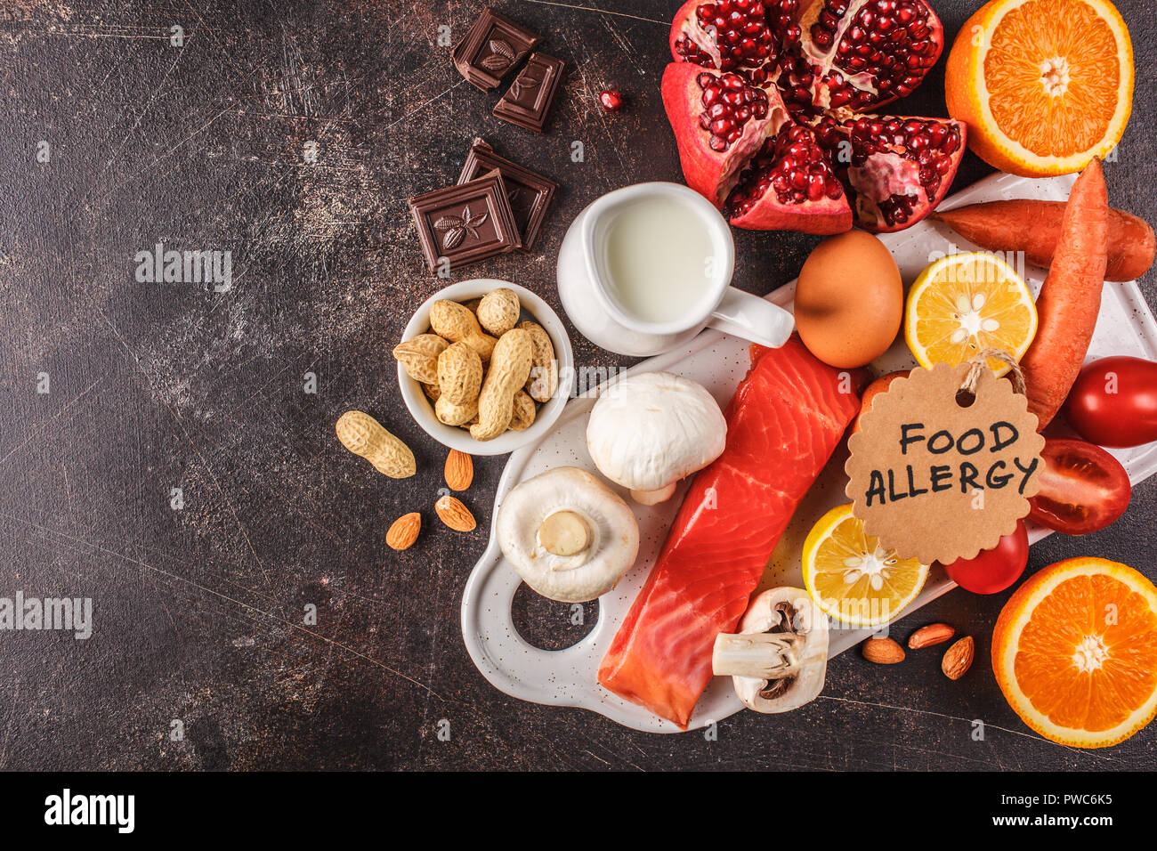 Allergie essen Konzept. Allergien, Fisch, Eier, Zitrusfrüchte, Schokolade, Pilze und Nüsse. Gesundheit und Medizin in Essen. Dunkler Hintergrund, Ansicht von oben, c Stockfoto