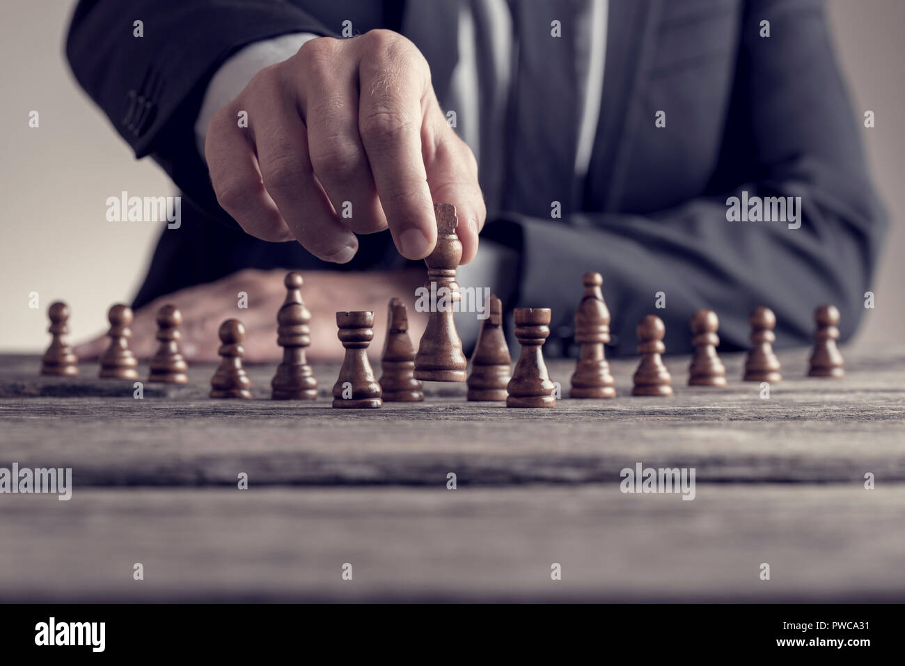 Retro Style Bild von einem Geschäftsmann spielen eine Partie Schach auf  einem alten Holztisch in der Nähe zu sehen, der seine Hand bewegt ein Stück  konzeptionelle Strategie Stockfotografie - Alamy
