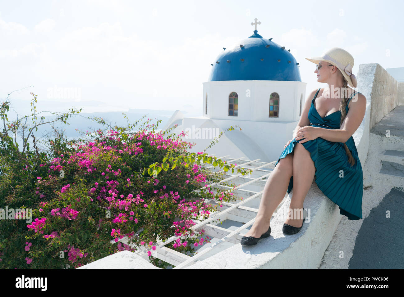 Glückliche Frau im grünen Kleid und Sun hat ihren Urlaub auf Santorini, Griechenland genießen. Blick auf Caldera und die Ägäis von Imerovigli. Stockfoto